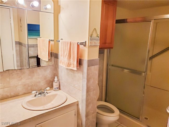 Full bath with toilet, tile walls, a stall shower, decorative backsplash, and vanity | Image 18