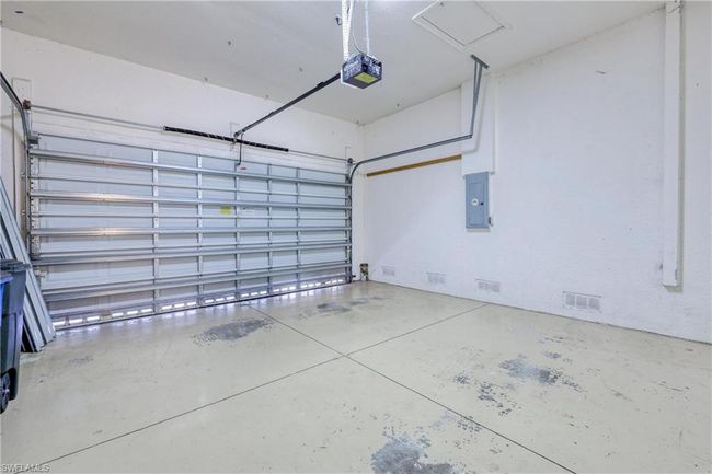 Garage featuring a garage door opener and electric panel | Image 11