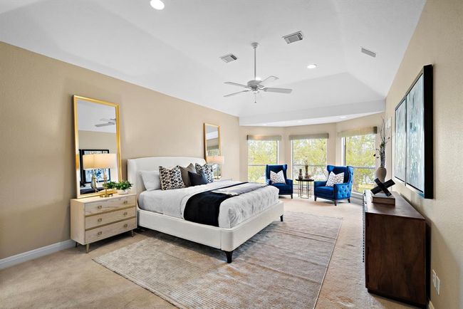 Primary bedroom suite is a spacious and luxurious retreat, bathed in natural light from the broad windows that offer panoramic views of the estate's grounds. | Image 22