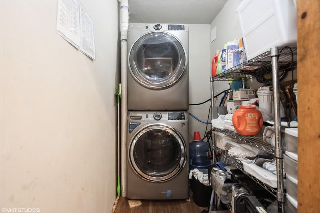 Laundry room featuring stacked washer and clothes dryer, laundry area, and wood finished floors | Image 13