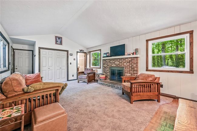 Relax by the fireplace in this warm and welcoming living room. | Image 7