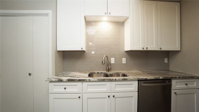 The kitchen has a nice light above the sink and offers plenty of cabinet space | Image 10