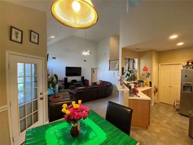 Dining space with high vaulted ceiling and ceiling fan | Image 17