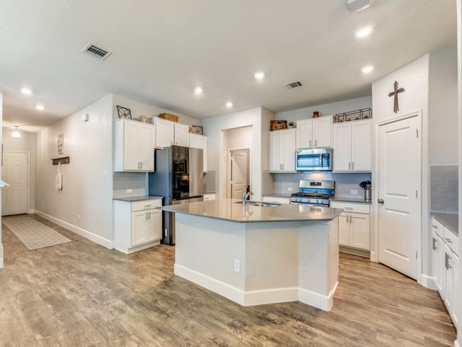 Kitchen featuring appliances with stainless steel finishes, recessed lighting, tasteful backsplash, white cabinets, and light wood-style floors | Image 12