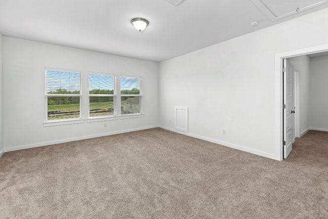 Carpeted empty room featuring attic access, baseboards, and a smoke detector | Image 27