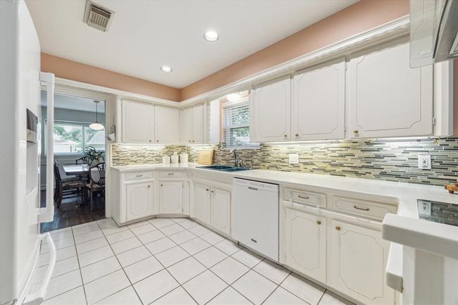 Bright kitchen with a triple-pane window offering views of the spacious corner lot. | Image 10