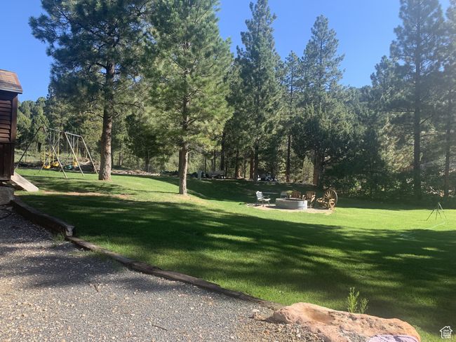 View of community featuring a lawn, a fire pit, and playground community | Image 27