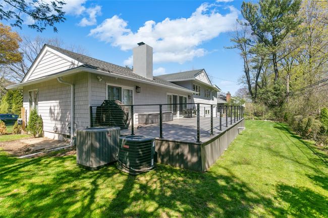 Back of property featuring a chimney, a yard, central air condition unit, and a wooden deck | Image 31