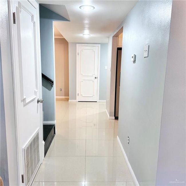 Hallway featuring light tile patterned floors and baseboards | Image 5