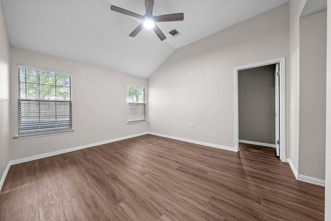 Unfurnished room with a ceiling fan, vaulted ceiling, dark wood-style flooring, and baseboards | Image 20