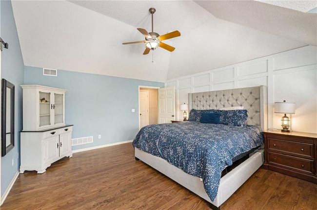 Bedroom with wood finished floors, baseboards, high vaulted ceiling, and ceiling fan | Image 29