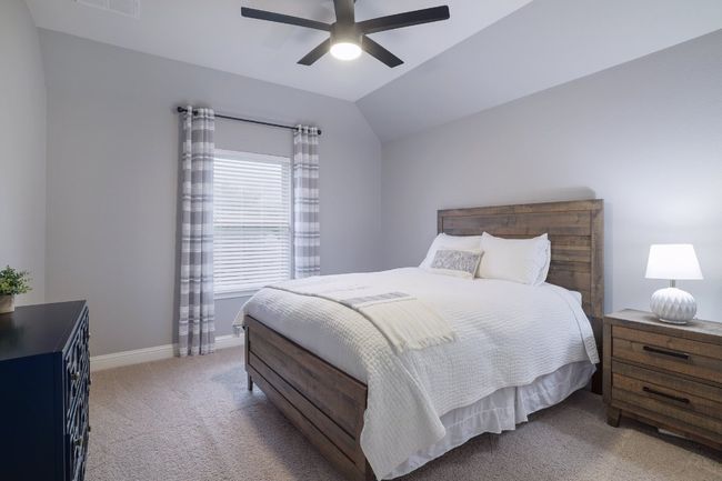 Bedroom with light colored carpet, baseboards, a ceiling fan, and vaulted ceiling | Image 28
