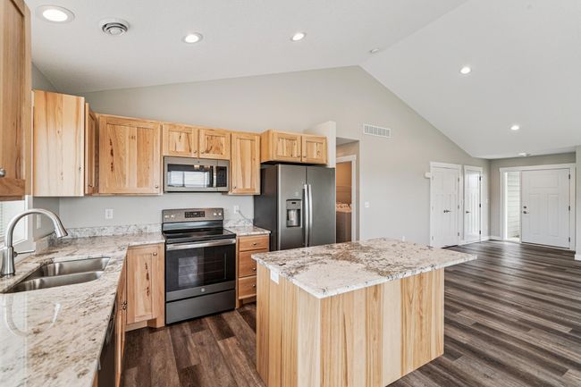 Kitchen features vaulted ceilings, birch cabinets, granite countertops, center island, S.S. appliances, and LVP flooring. | Image 9