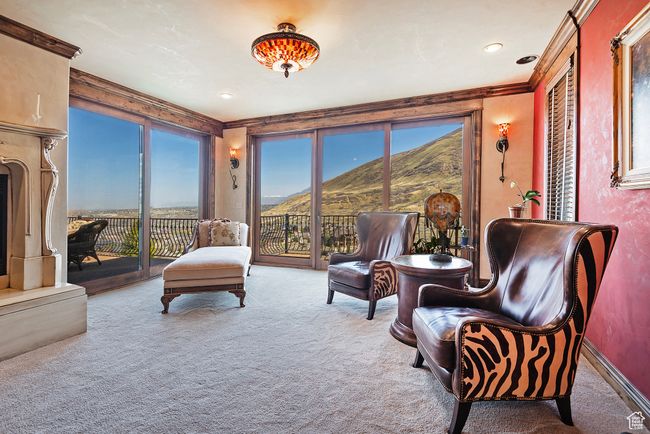 Living area featuring a wealth of natural light, a mountain view, ornamental molding, and carpet floors | Image 30