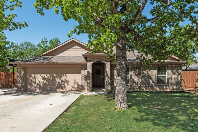 Ranch-style house with a shingled roof, a garage, fence, concrete driveway, and a front lawn | Image 4