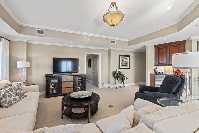 Living room featuring a raised ceiling, ornamental molding, light colored carpet, and recessed lighting | Image 11