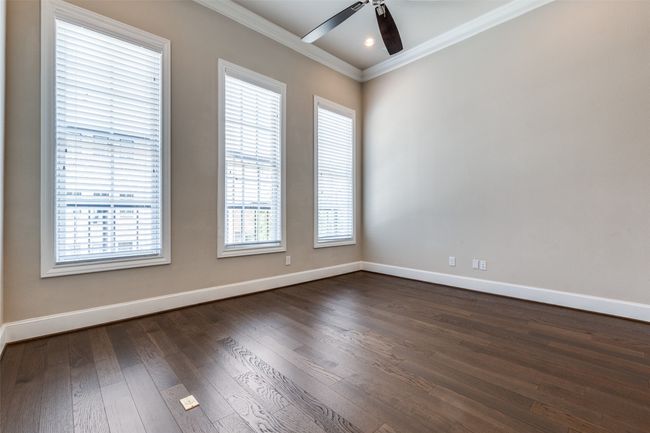 Unfurnished room with ornamental molding, a ceiling fan, and dark wood-style flooring | Image 21