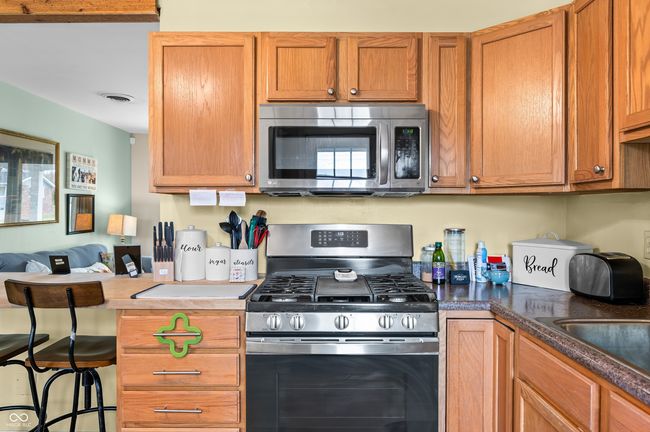 kitchen with a sink, open floor plan, visible vents, a kitchen bar, and appliances with stainless steel finishes | Image 19