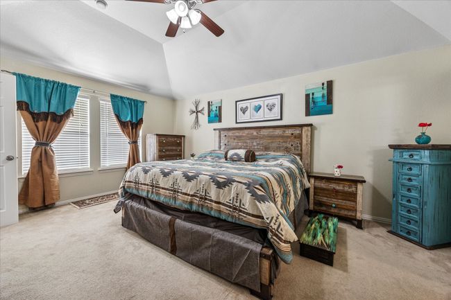 Spacious master bedroom featuring ample wall space, elevated ceilings, and a ceiling fan for added comfort and style. | Image 15