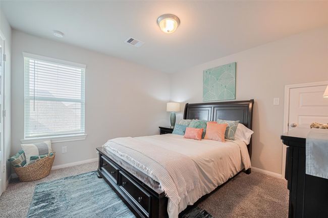 This bright bedroom features soft carpeting, a window with blinds for natural light, and a modern ceiling light fixture. | Image 39