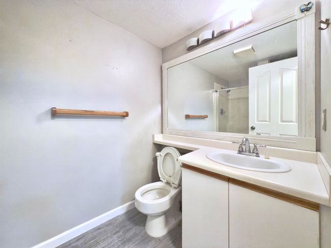 Full bath featuring a shower, baseboards, wood finished floors, toilet, and vanity | Image 11
