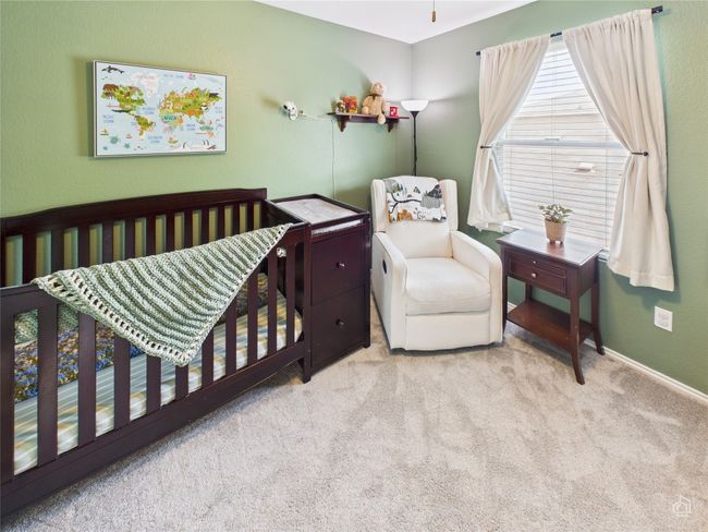Carpeted bedroom with a crib and baseboards | Image 19