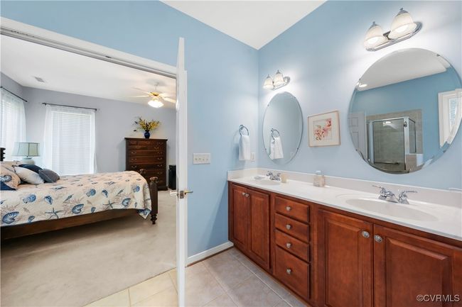 Bathroom featuring connected bathroom, tile patterned flooring, double vanity, a shower stall, and a ceiling fan | Image 28