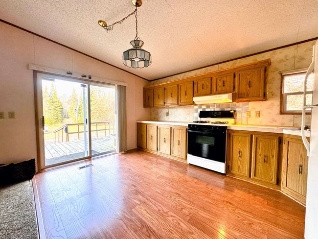 patio door off of the kitchen that leads to the wrap around deck | Image 6