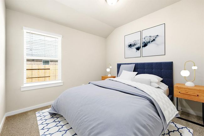 Secondary bedroom features plush carpet, neutral paint, lighting and a large window with privacy blinds. | Image 13