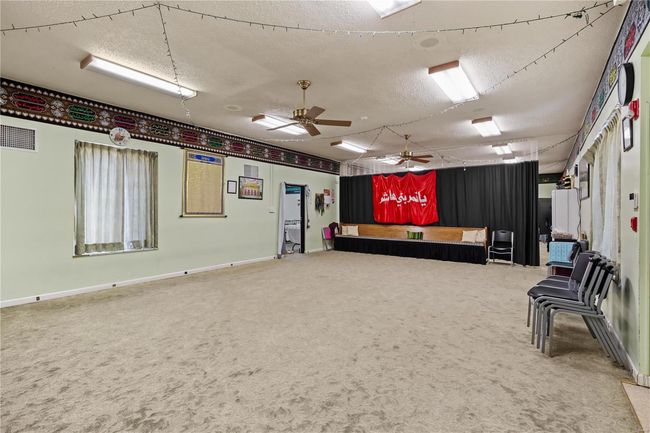 Misc room with visible vents, baseboards, carpet, a textured ceiling, and a ceiling fan | Image 28