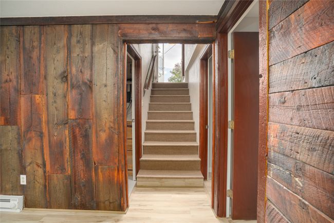 Staircase featuring wood finished floors, a baseboard heating unit, and wooden walls | Image 20