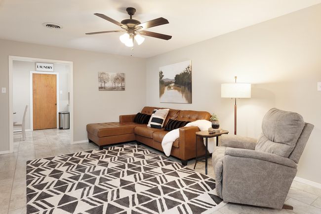 Living room with visible vents, baseboards, and ceiling fan | Image 16