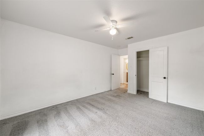 Unfurnished bedroom featuring carpet flooring, a closet, a ceiling fan, and baseboards | Image 18