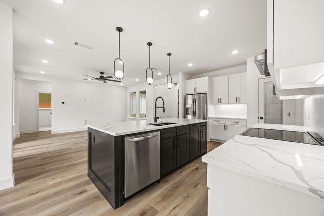 Kitchen featuring appliances with stainless steel finishes, a sink, ceiling fan, white cabinetry, and light wood-style floors | Image 11