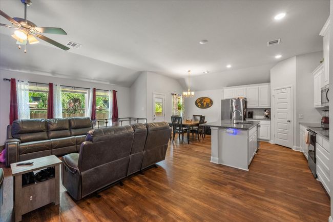 Living room with vaulted ceiling, a chandelier, dark wood-style floors, recessed lighting, and a ceiling fan | Image 12