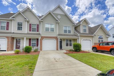 Multi unit property with a front yard and a garage | Image 1