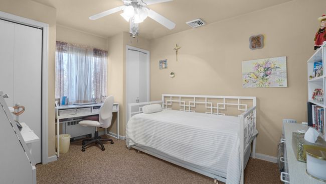 Carpeted bedroom featuring baseboards, ceiling fan, and visible vents | Image 9