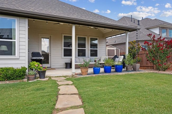 Back of house with covered patio, ceiling fans, pavers and shed on the side | Image 29