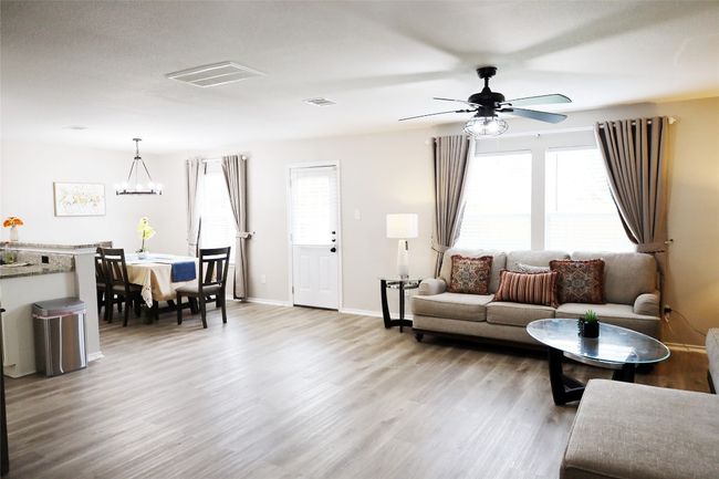 Living area featuring a ceiling fan, light wood-style flooring, baseboards, and visible vents | Image 4
