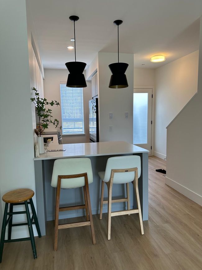 Kitchen featuring refrigerator, a breakfast bar area, light wood-style flooring, and pendant lighting | Image 9