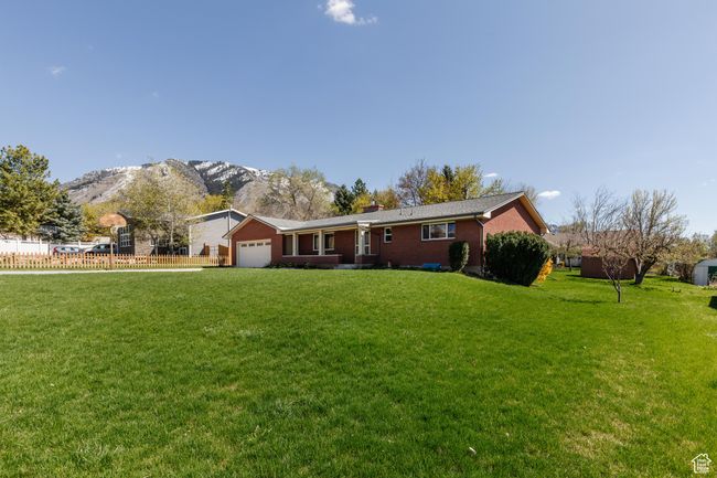 Single story home with an attached garage, a front yard, fence, and a mountain view | Image 38