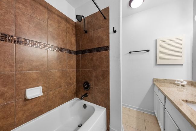 Bathroom with tiled shower / bath combo, Quartz Countertop Vanity and tile patterned flooring | Image 23