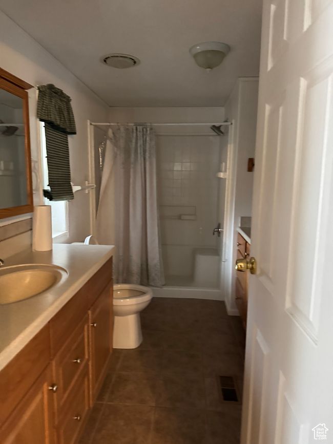 Full bath with vanity, curtained shower, toilet, and tile patterned flooring | Image 17