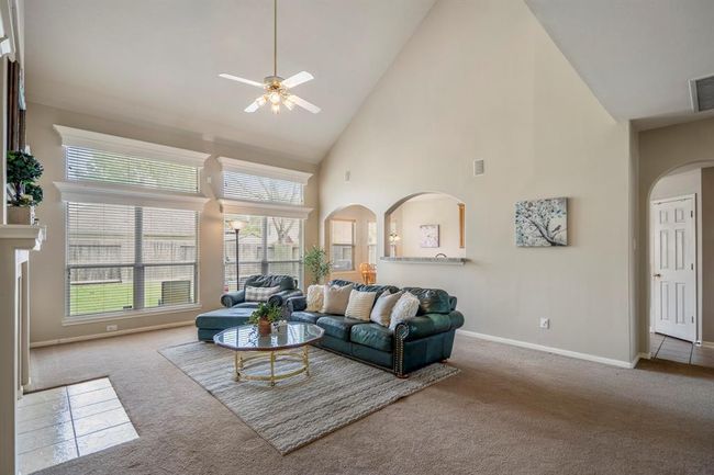 Exiting the primary suite and moving back into the living area, this vantage point offers a clear view of the doorway that leads back to the kitchen, near the stairs. You also get another look at the living room, showcasing the soaring ceilings and spacious layout. | Image 23