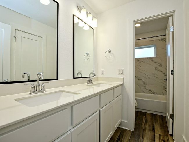 Bathroom with double vanity, wood finished floors, and shower / bathtub combination | Image 21