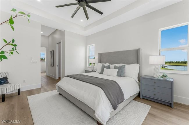 Bedroom with wood finished floors, a tray ceiling, recessed lighting, and ceiling fan | Image 12