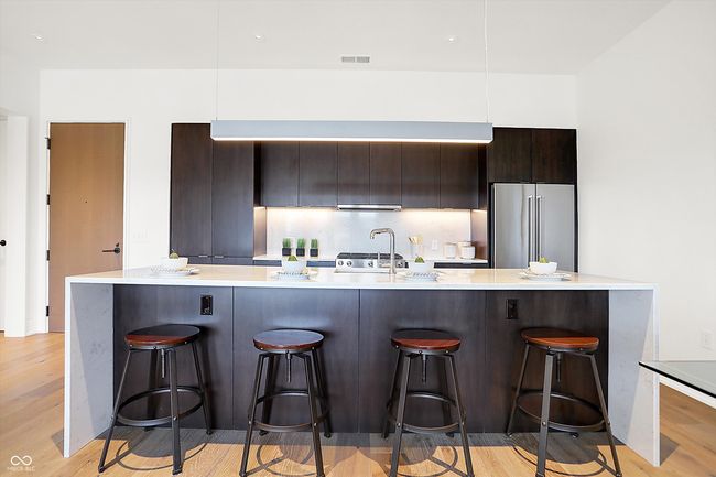 The kitchen has a pantry and large center island with ample space for seating | Image 7