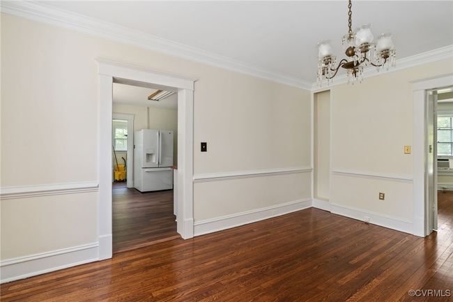 Dining room featuring hardwood floors, plenty of natural light, a chandelier, crown molding, and baseboards, next to kitchen | Image 17