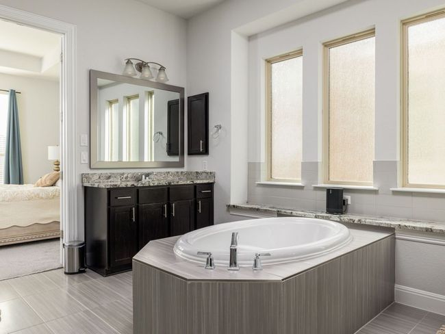 Ensuite bathroom featuring tile patterned floors, vanity, connected bathroom, and a bath | Image 17