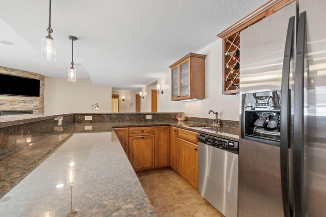 Entertain at your lower level wet bar complete with refrigerator, dishwasher, and lots of storage. | Image 55
